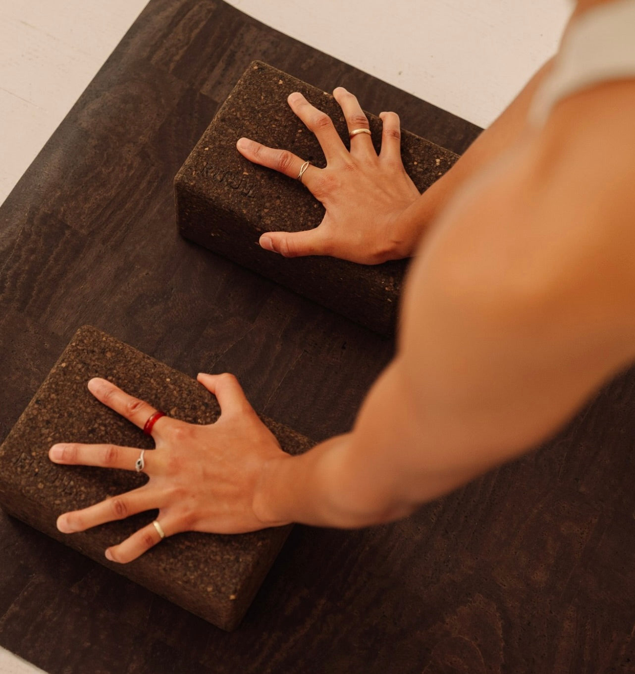 woman practicing yoga and pilates on extra long and extra thick brown cork yoga mat with hands on brown yoga blocks