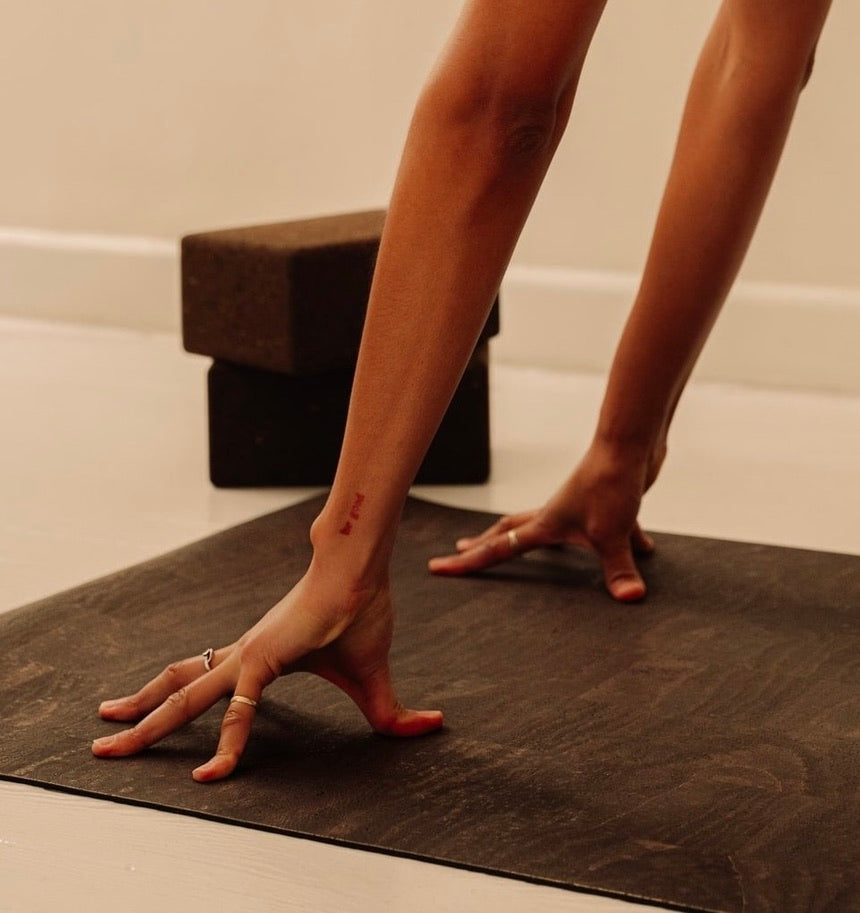 non slip cork yoga mat in brown with woman hands pressing in